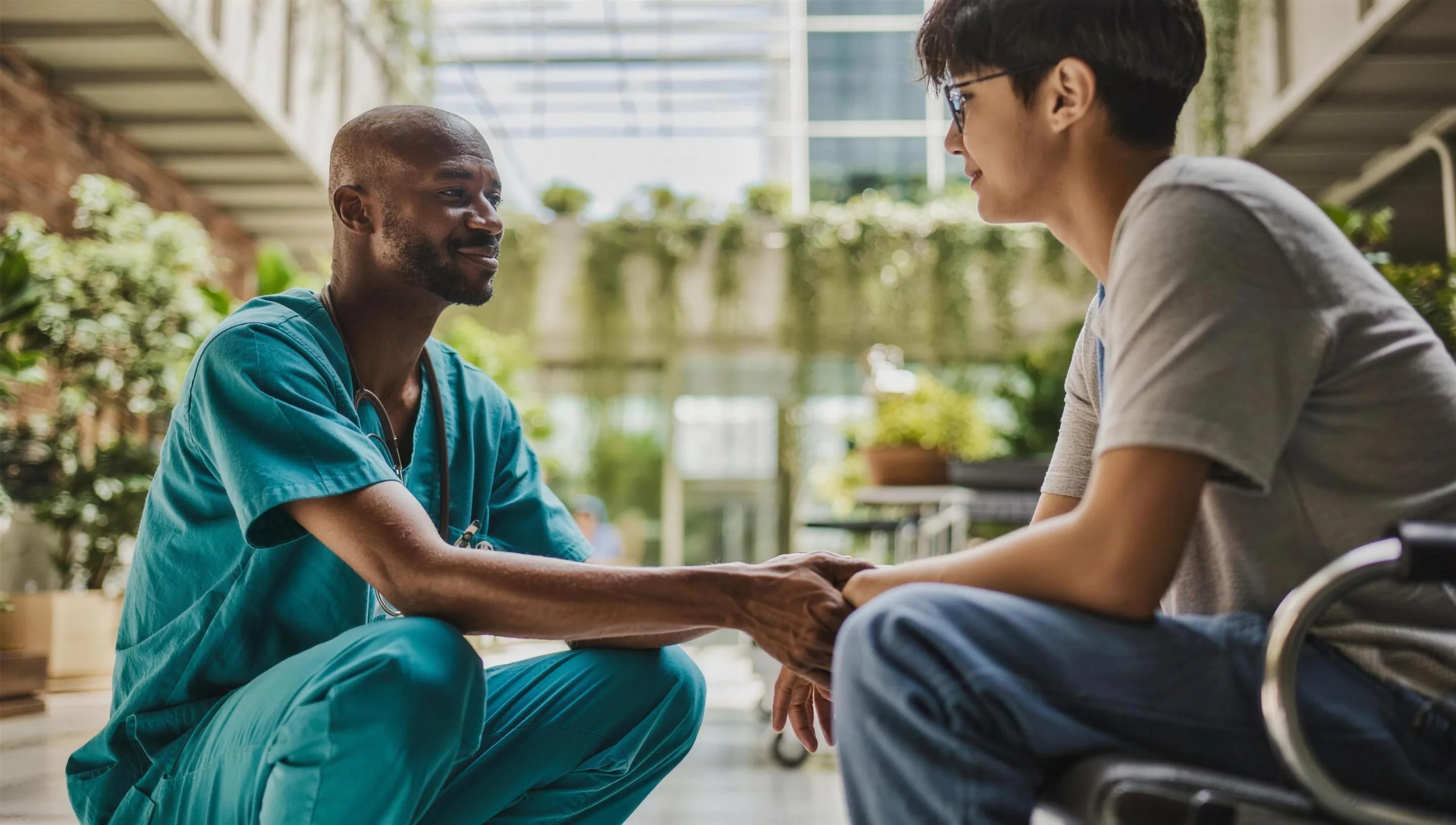 A doctor talking with a patient in a wheelchair